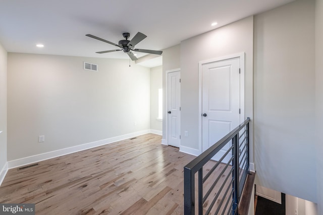 spare room with ceiling fan, lofted ceiling, and light hardwood / wood-style flooring