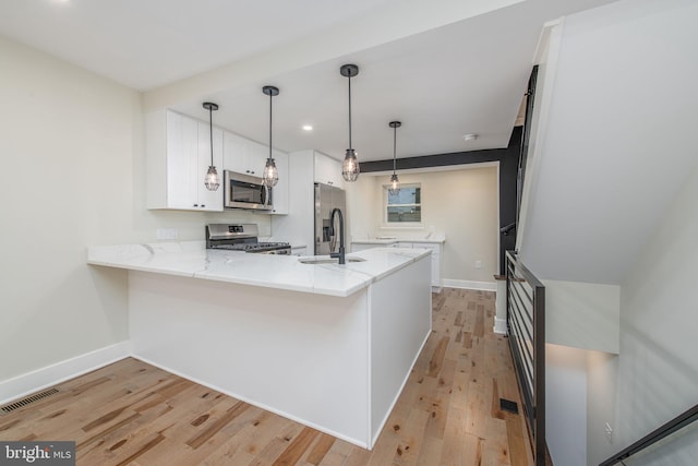 kitchen with kitchen peninsula, appliances with stainless steel finishes, sink, light hardwood / wood-style flooring, and white cabinets