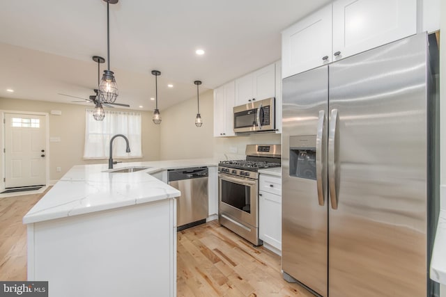 kitchen with sink, light stone counters, light hardwood / wood-style flooring, white cabinets, and appliances with stainless steel finishes