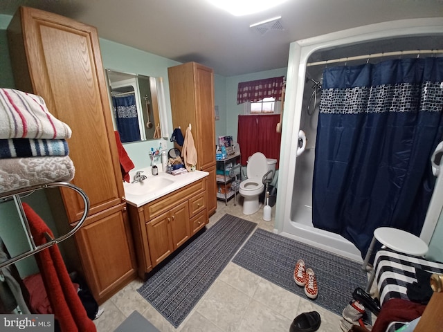 bathroom featuring toilet, a shower with shower curtain, tile patterned flooring, and vanity