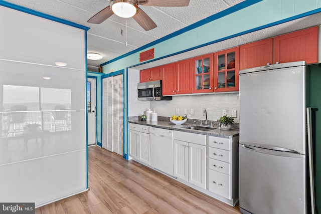 kitchen featuring ceiling fan, sink, light hardwood / wood-style floors, a textured ceiling, and appliances with stainless steel finishes