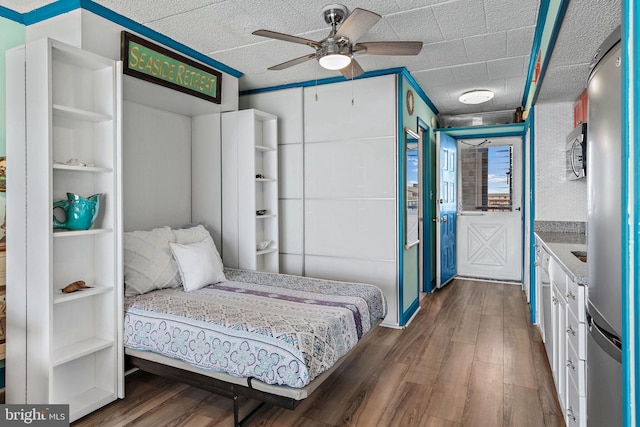 bedroom featuring a textured ceiling, ceiling fan, and dark wood-type flooring