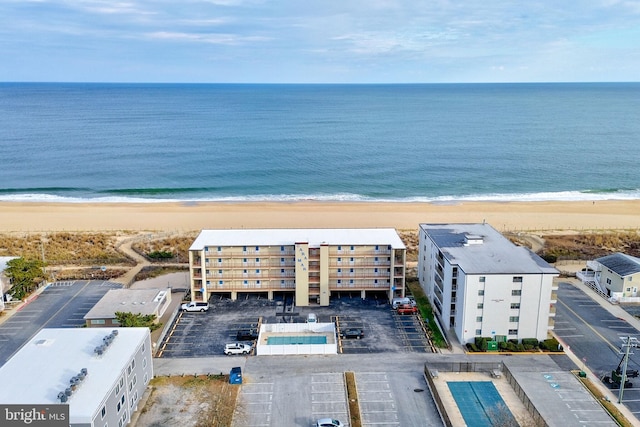 drone / aerial view with a water view and a beach view