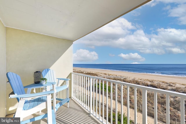 balcony featuring a water view and a beach view