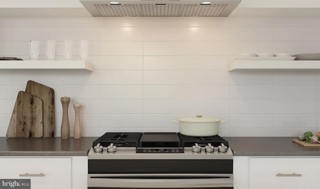 kitchen featuring backsplash, extractor fan, tile walls, range, and white cabinetry