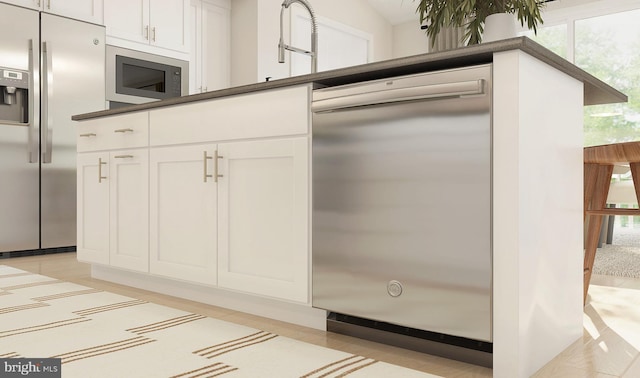 kitchen featuring white cabinets, stainless steel appliances, plenty of natural light, and sink