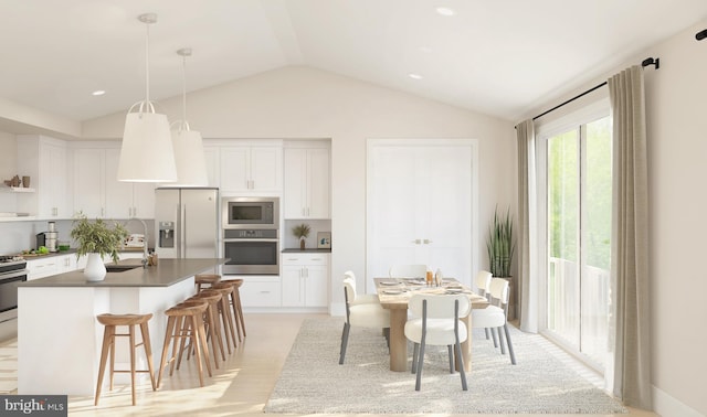 kitchen with light wood-type flooring, stainless steel appliances, decorative light fixtures, white cabinetry, and lofted ceiling