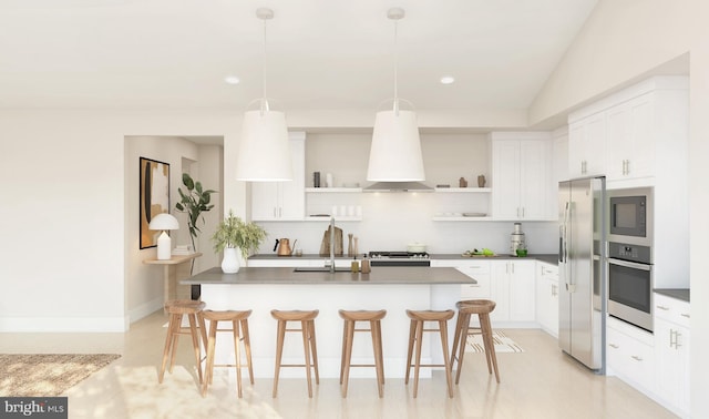 kitchen featuring a kitchen bar, appliances with stainless steel finishes, custom range hood, pendant lighting, and white cabinetry