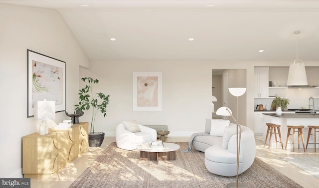 living room featuring lofted ceiling and sink