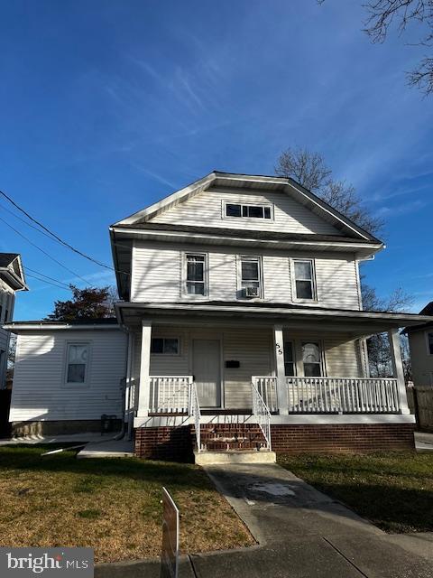 view of front of house featuring covered porch and a front yard