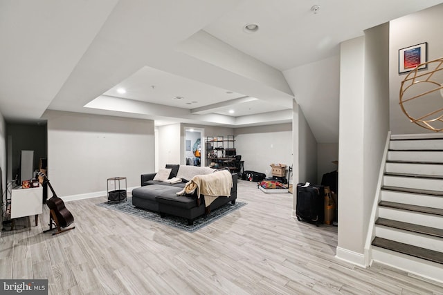 bedroom with a raised ceiling and light wood-type flooring