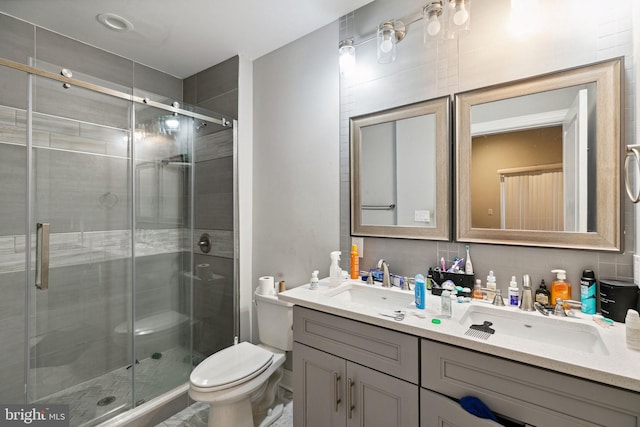 bathroom with vanity, a shower with door, and toilet