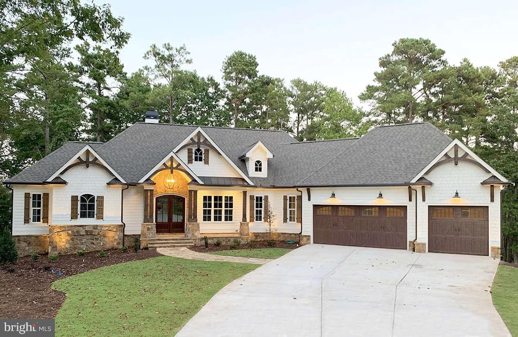 view of front facade featuring a front yard, french doors, and a garage