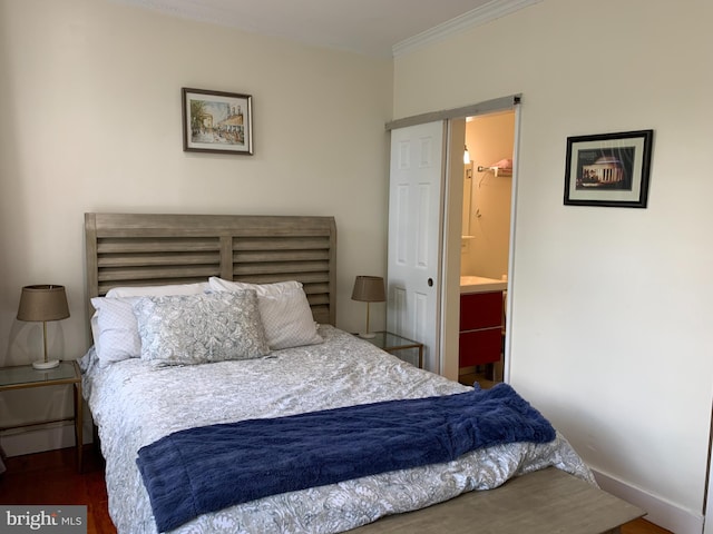 bedroom featuring connected bathroom, dark hardwood / wood-style floors, and crown molding