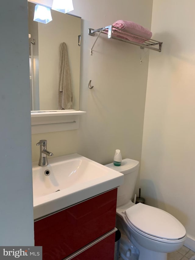 bathroom with tile patterned flooring, vanity, and toilet