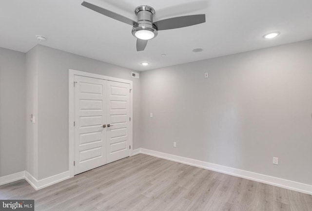 unfurnished bedroom with a closet, light hardwood / wood-style flooring, and ceiling fan