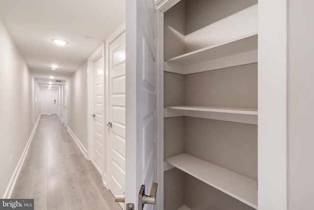 hallway with light hardwood / wood-style floors