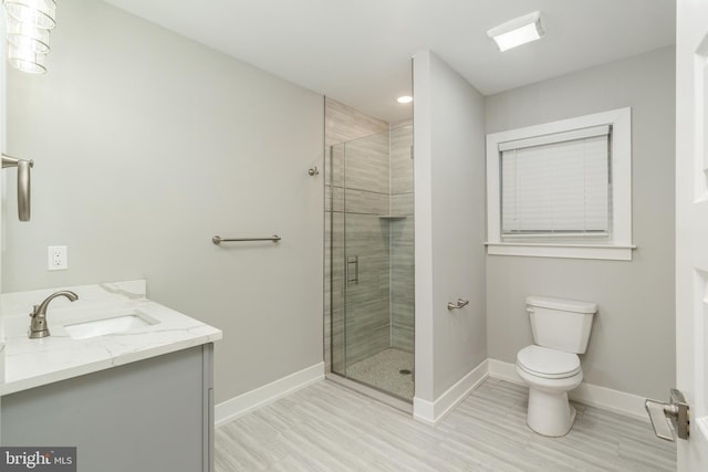 bathroom with hardwood / wood-style floors, toilet, an enclosed shower, and vanity