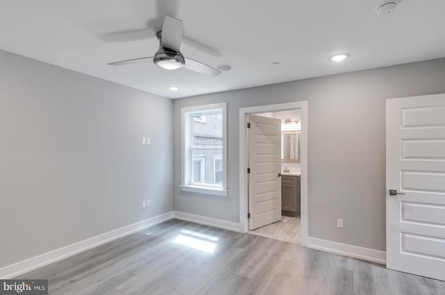 unfurnished bedroom featuring connected bathroom, ceiling fan, and light hardwood / wood-style floors