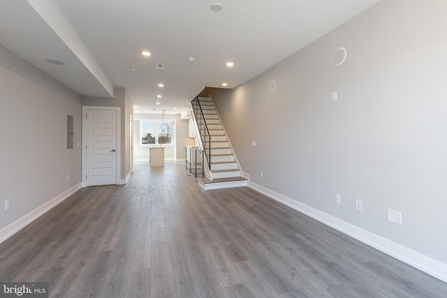 unfurnished living room with electric panel and dark hardwood / wood-style floors