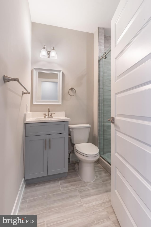 bathroom with vanity, toilet, and a shower with shower door