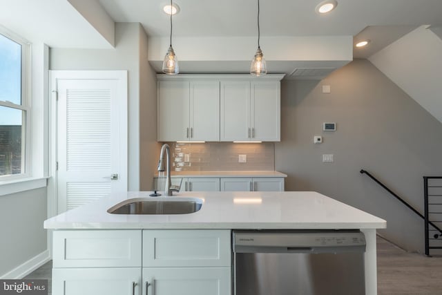 kitchen with light stone countertops, sink, decorative light fixtures, dishwasher, and white cabinetry