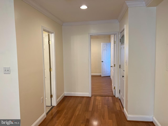 corridor with hardwood / wood-style floors and ornamental molding