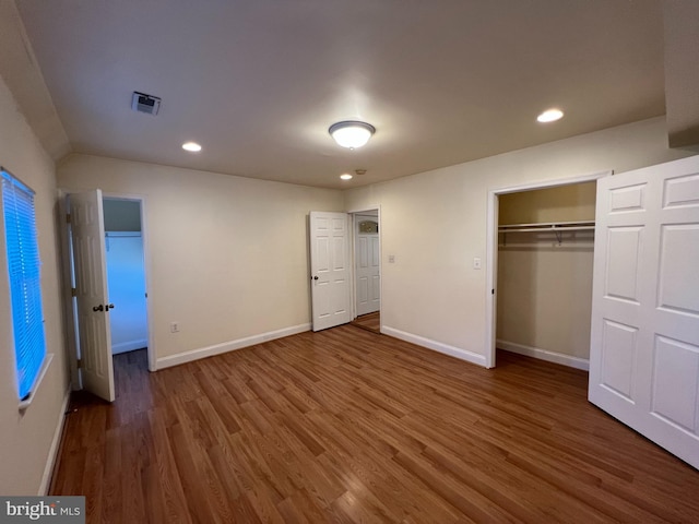 unfurnished bedroom featuring a closet and dark wood-type flooring