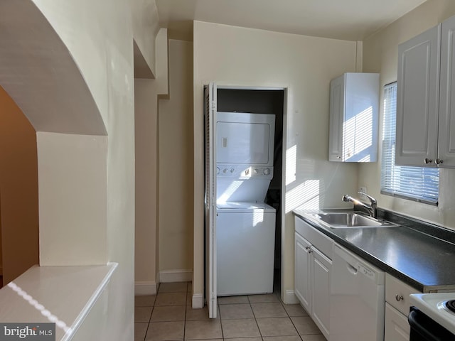 laundry room with light tile patterned floors, stacked washer and clothes dryer, and sink