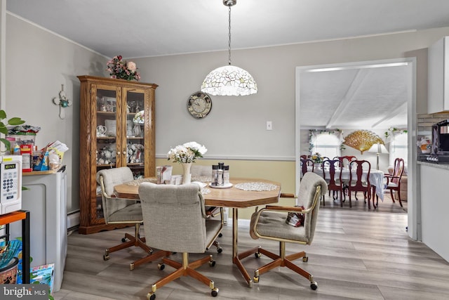 dining area with baseboard heating and light hardwood / wood-style floors