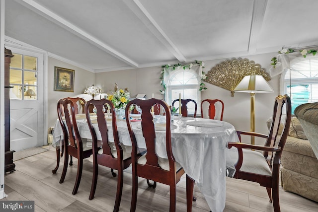 dining space featuring lofted ceiling with beams