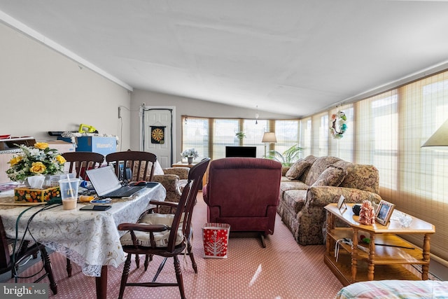 carpeted dining space with lofted ceiling