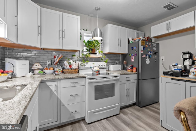 kitchen featuring stainless steel fridge, decorative backsplash, white cabinetry, and white electric range