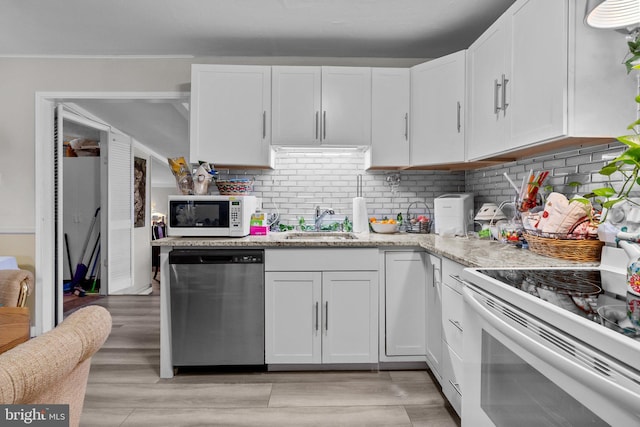 kitchen with white cabinets, decorative backsplash, white appliances, and sink