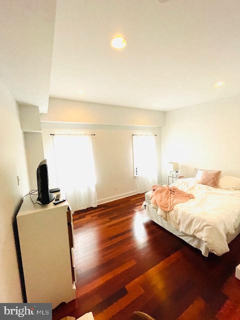 bedroom with dark hardwood / wood-style floors