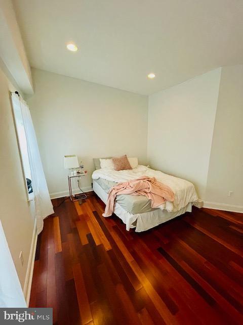 bedroom with dark hardwood / wood-style flooring