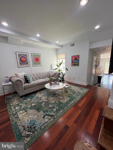 living room with a wealth of natural light and dark hardwood / wood-style flooring