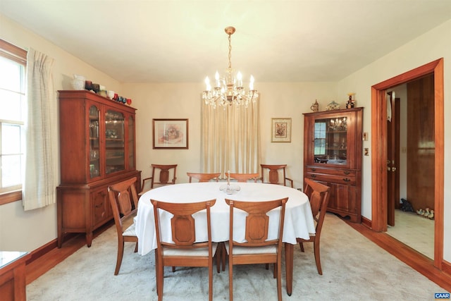 dining area with light hardwood / wood-style floors and a chandelier