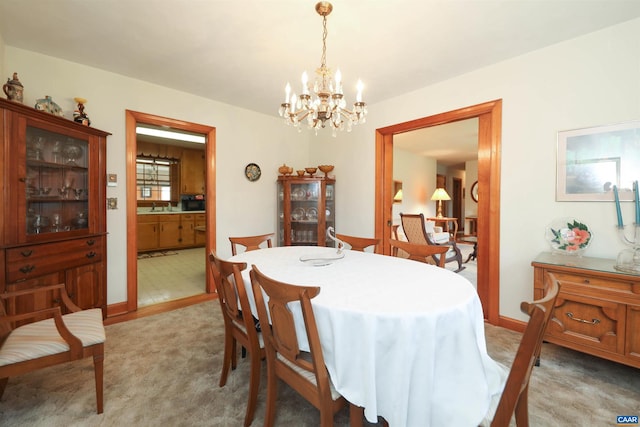 carpeted dining space with sink and a chandelier