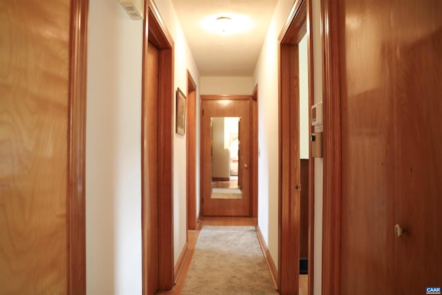 corridor featuring light colored carpet