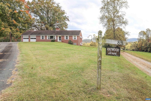 ranch-style house with a garage and a front lawn