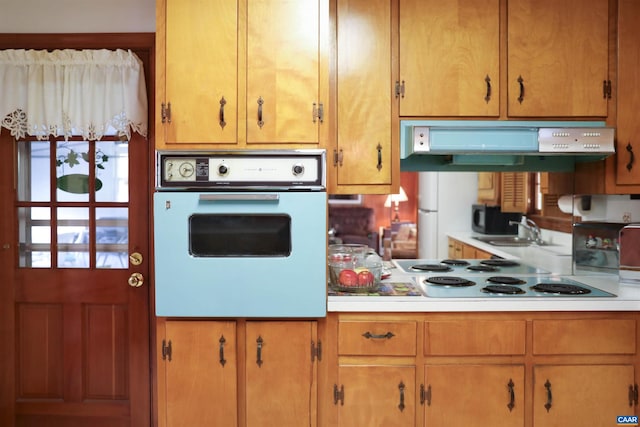 kitchen featuring wall oven, white refrigerator, sink, and stovetop