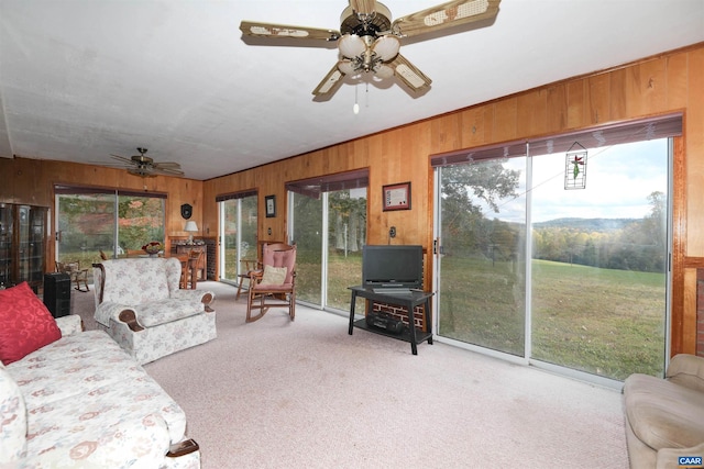 living room featuring ceiling fan, a wealth of natural light, and light carpet