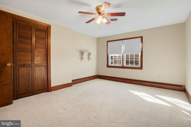 unfurnished bedroom with ceiling fan, light carpet, and a baseboard heating unit