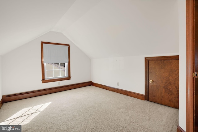 bonus room with vaulted ceiling, light carpet, and a baseboard heating unit