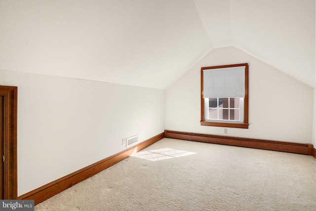 bonus room featuring baseboard heating, carpet, and vaulted ceiling