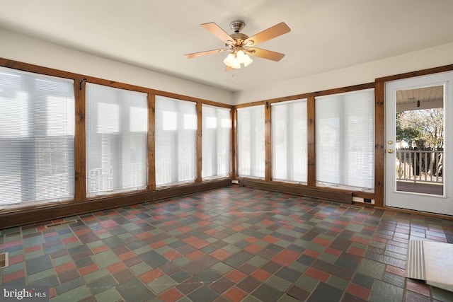 unfurnished sunroom with ceiling fan