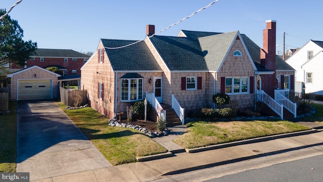 view of front of property with a garage, an outbuilding, and a front lawn