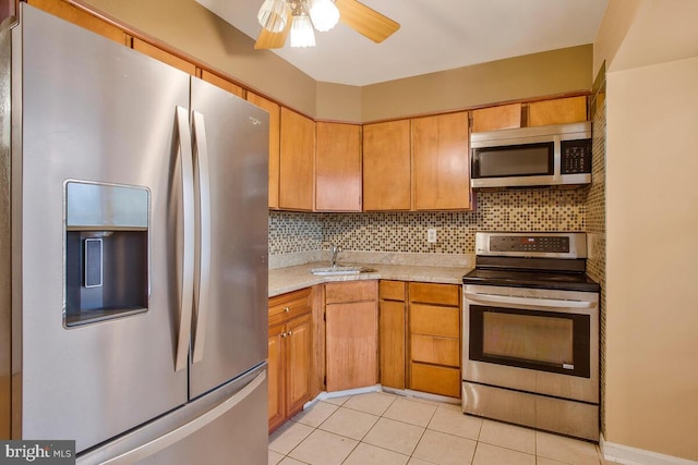 kitchen featuring decorative backsplash, appliances with stainless steel finishes, ceiling fan, sink, and light tile patterned floors