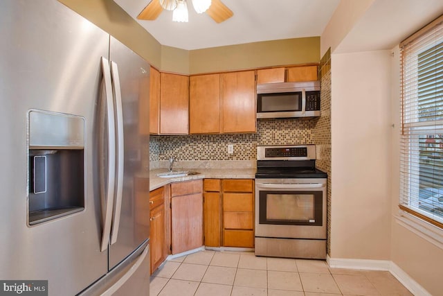 kitchen with tasteful backsplash, stainless steel appliances, ceiling fan, sink, and light tile patterned floors